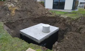 Zbiornik na deszczówkę w wykopie, przygotowywany do zakopania. Ekologiczne rozwiązanie dla domu.