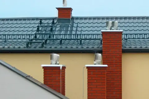 Różne rodzaje wentylacji kominowej na dachu: obrotowe nasady kominowe zapewniające ciągły przepływ powietrza.