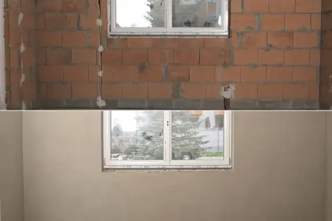 Przed i po: ściana z pustaków ceramicznych z instalacją, a następnie gładka, gotowa do malowania dzięki nałożeniu tynku na ścianę.