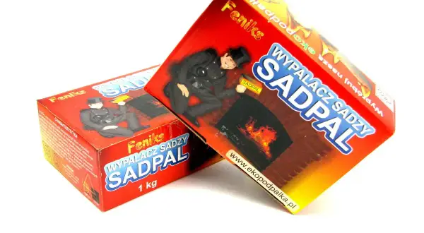 Dwie czerwone paczki "SADPAL" z kominiarzem i płonącym kominkiem. Produkt do usuwania sadzy.