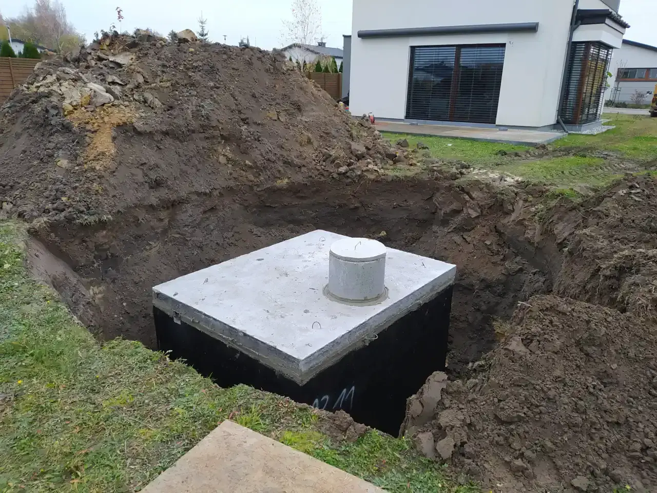 Zbiornik na deszczówkę w wykopie, przygotowywany do zakopania. Ekologiczne rozwiązanie dla domu.
