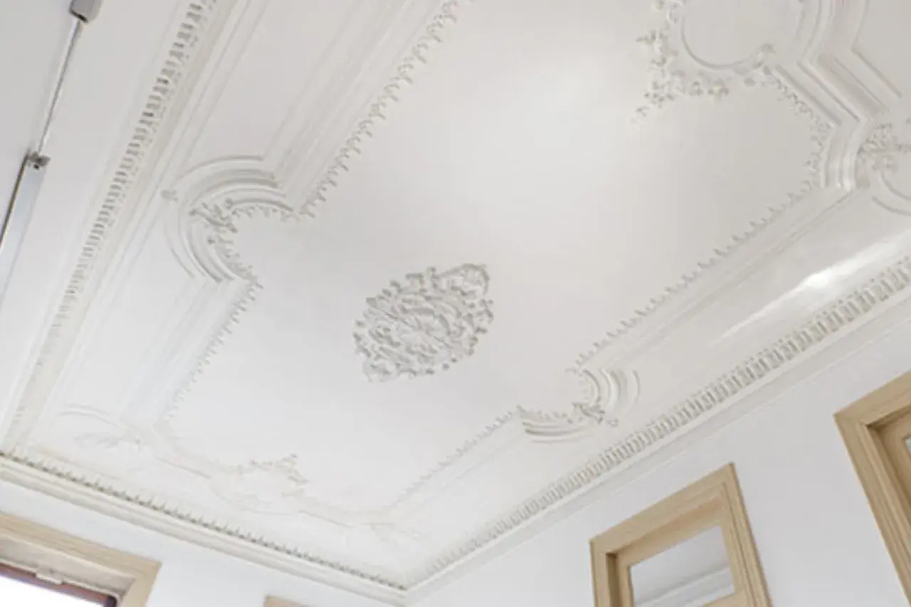Elegancki sufit z bogatą sztukaterią. Sprawdź, jaka jest montaż sztukaterii cena i odmień swoje wnętrze.