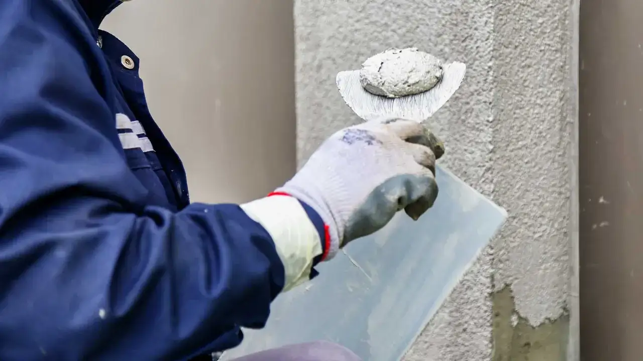 Pracownik nakłada tynk silikonowy na ścianę. Sprawdź atrakcyjną cenę za m2 robocizny.