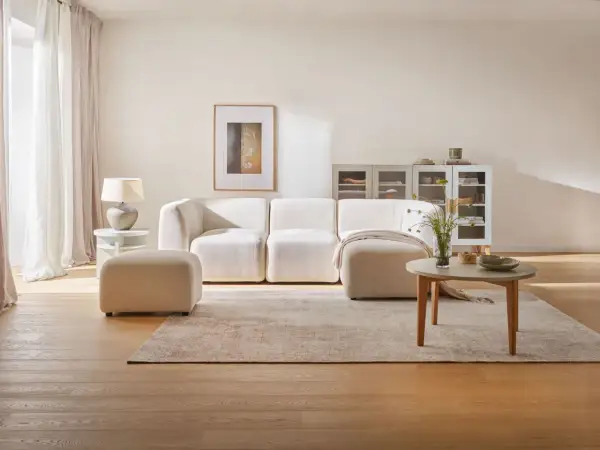 Jasne, oto propozycja:

Jasne, neutralne kolory ścian do salonu tworzą przytulną atmosferę. Miękka sofa, dywan i drewniane meble dopełniają aranżację.